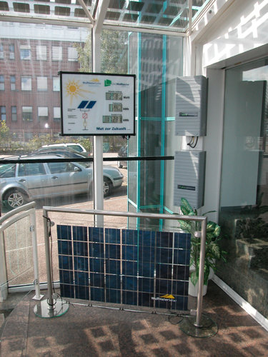 Beispiel einer Balkonverglasung mit Solarzellen - Im Display werden die Leistungsdaten unserer Photovoltaikanlagen angezeigt